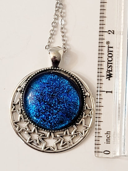 Silver tone Moon and Stars Celestial Pendant Necklace with Blue dichroic glass cabochon on a 20 inch steel metal chain. seeds glassworks seedsglassworks