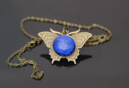 Butterfly pendant necklace, brass tone with blue dichroic fused glass center stone on a 20 inch brass chain