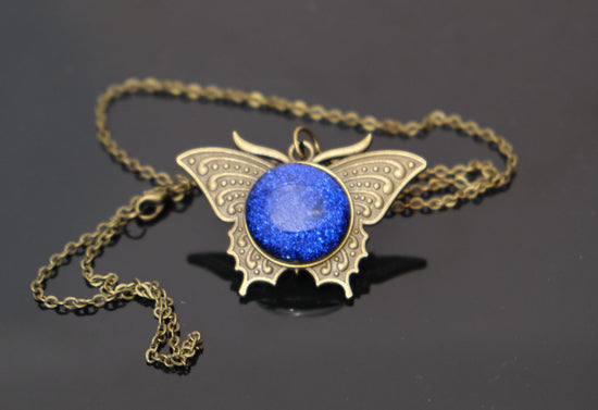 Butterfly pendant necklace, brass tone with blue dichroic fused glass center stone on a 20 inch brass chain seeds glassworks seedsglassworks