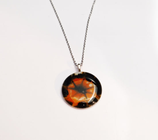 Tie Dye look Halloween fused glass pendant necklace jewelry in black, white and orange on 20 inch steel chain seeds glassworks seedsglassworks