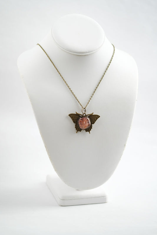 Butterfly pendant necklace, antiqued brass tone with orange dichroic fused glass center stone on a 20 inch antiqued brass chain seeds glassworks seedsglassworks