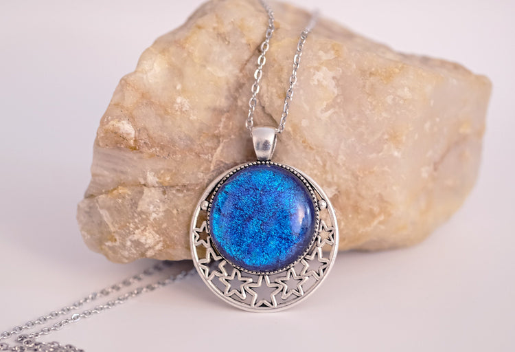 Silver tone Moon and Stars Celestial Pendant Necklace with Blue dichroic glass cabochon on a 20 inch steel metal chain.