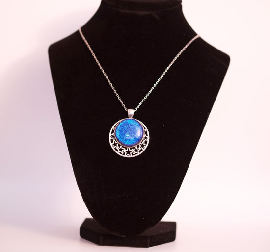 Silver tone Moon and Stars Celestial Pendant Necklace with Blue dichroic glass cabochon on a 20 inch steel metal chain. seeds glassworks seedsglassworks