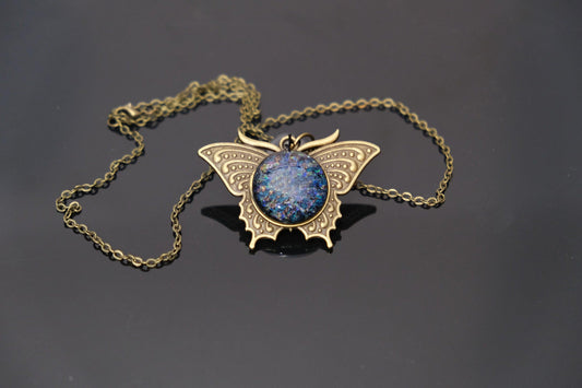 Butterfly pendant necklace, brass tone with blue/multicolor dichroic fused glass center stone on a 20 inch brass toned chain seeds glassworks seedsglassworks